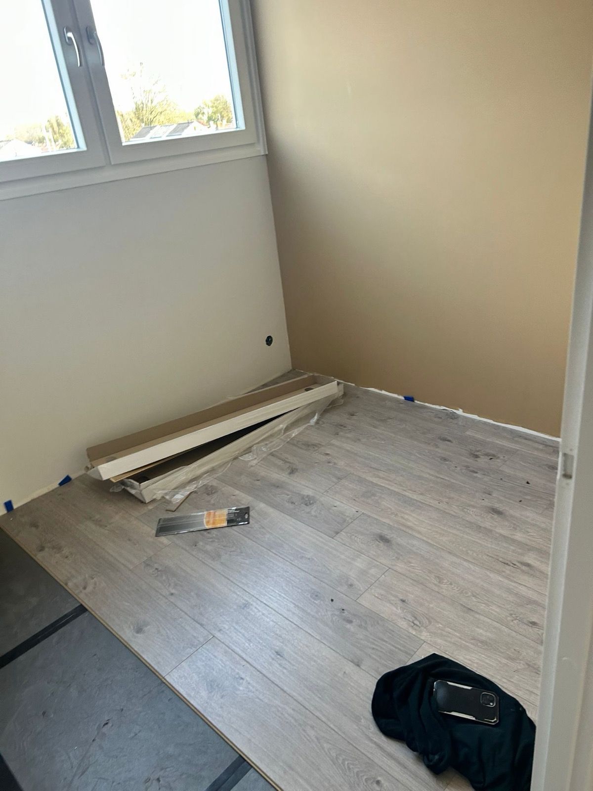 Nieuwe lichtgrijze laminaatvloer in slaapkamer